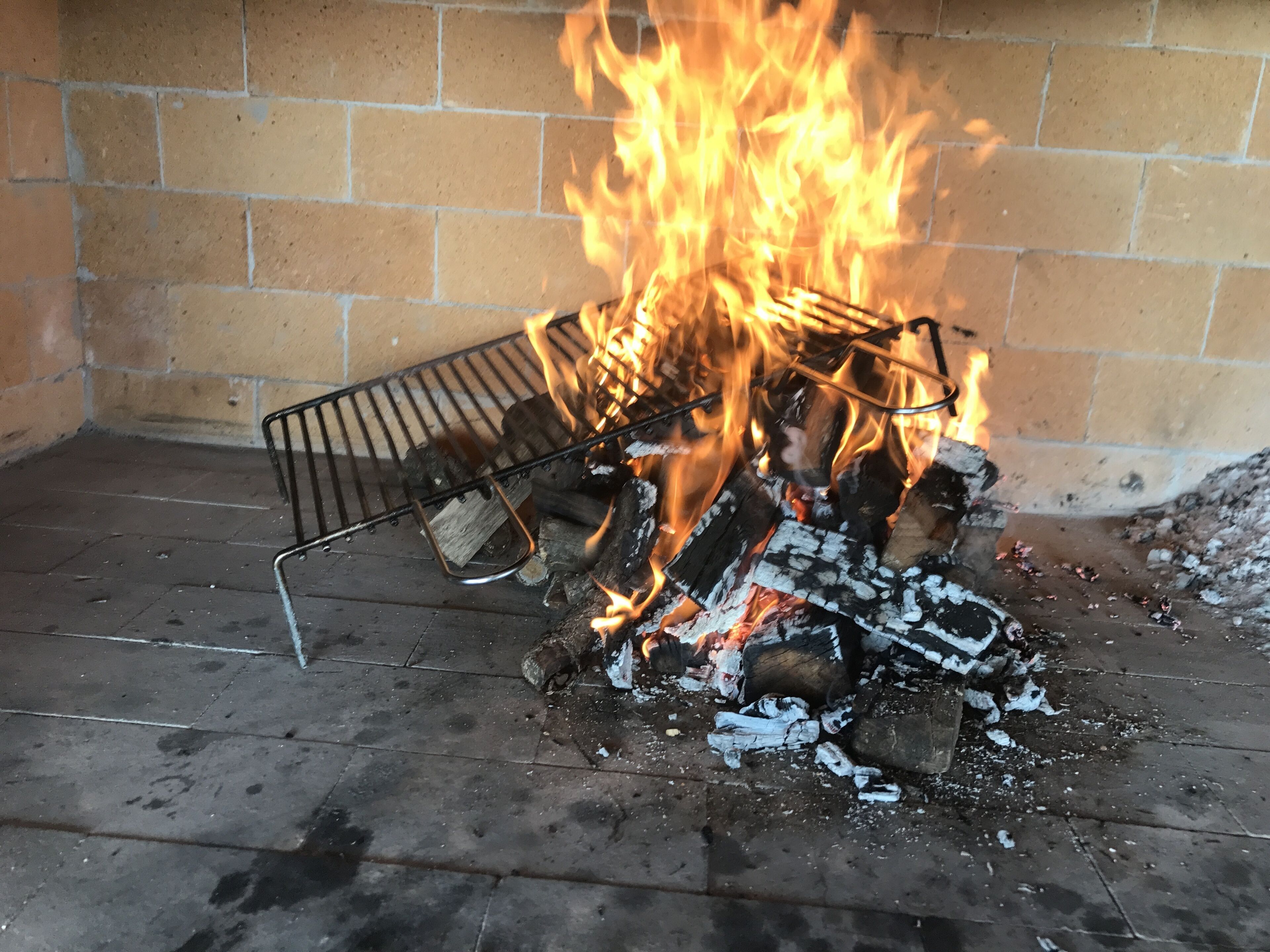 Un fuego ardiendo en una chimenea con una rejilla de metal.