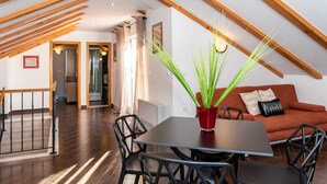 A dining area with a table, chairs, and a potted plant. - Apartments Sutalo (Konavle)