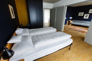 Una habitación con una cama grande, un escritorio, una silla y un sofá.