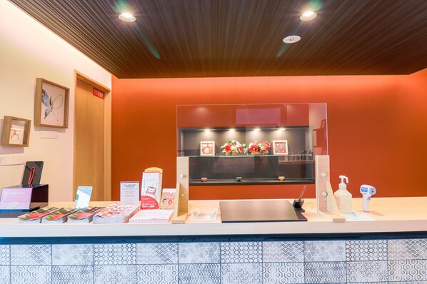 A reception desk with a check-in counter, a digital display, and informational brochures. - Stay SAKURA Kyoto TSUBAKI (Kyoto)