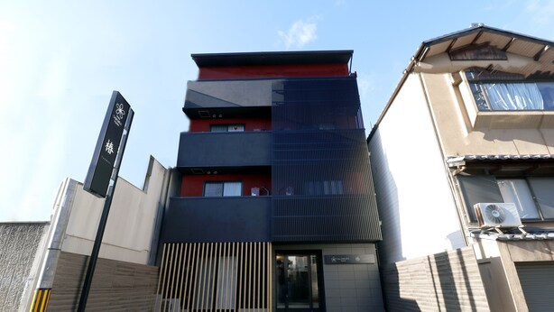 A multi-story building with a modern design, featuring a combination of red, black, and beige colors. - Stay SAKURA Kyoto TSUBAKI (Kyoto)