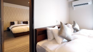 A hotel room with a large bed, a wooden headboard, and an air conditioning unit on the wall. - Stay SAKURA Kyoto TSUBAKI (Kyoto)