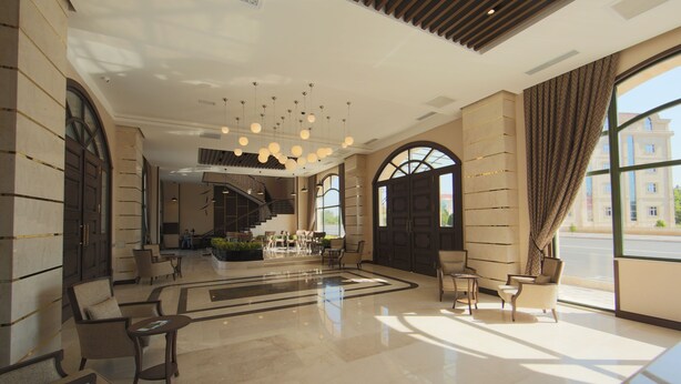 A spacious lobby with a central staircase, seating areas, and large windows offering views of the outside. - Saat Meydani Hotel (Nakhchivan)