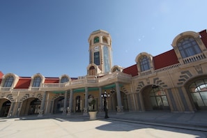 A historic building with a central tower, arched windows, and a covered entrance area.