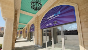 A cinema entrance with a marquee reading "CINEMAPLUS PREMIUM KINOTEATR" and a website URL. - Saat Meydani Hotel (Nakhchivan)