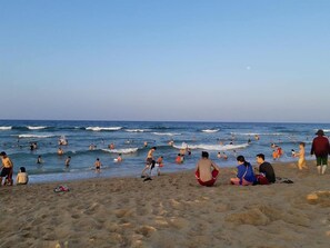 A beach with people swimming and walking on the sand. - HANID Hotel (Tuy Hoa)