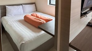 A modern bedroom with a bed, a red abstract painting, a window, and a TV mounted on the wall. - Front One Residence Syariah Mampang (Jakarta)