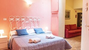 A bedroom with a bed, pillows, and a bedside table. - Lovely Studio in Trastevere (Rome)