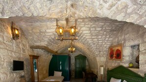 A rustic stone-walled room with two beds, a wooden dresser, and a green cabinet. - Hanehan Butik Otel (Sanliurfa)