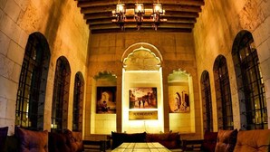 A historic building with arched windows, a central table, and benches. - Hanehan Butik Otel (Sanliurfa)