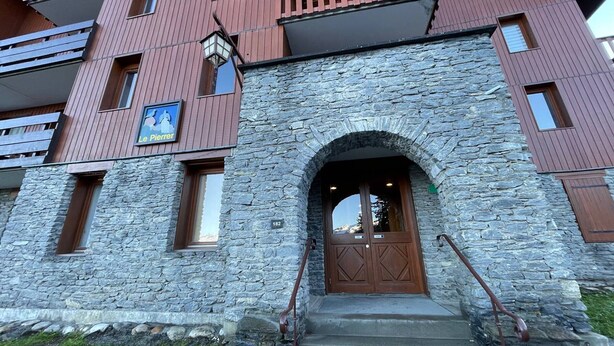 A stone building with a wooden door and a sign reading "Le Pierrier". - Divisible studio for 4 in Valmorel near slopes, shops and lifts (Valmorel)