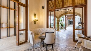 Un ambiente acogedor con una zona de estar con cojines, suelo estampado y vista a un patio exterior.
