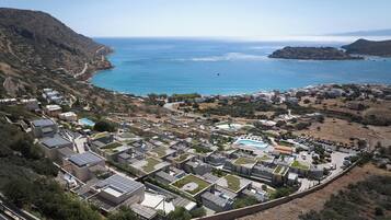 A coastal residential area with modern houses, a swimming pool, and a view of the sea.