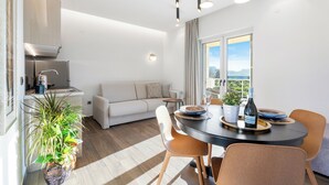 Cozinha moderna com área de refeições, um sofá e vista para o exterior.