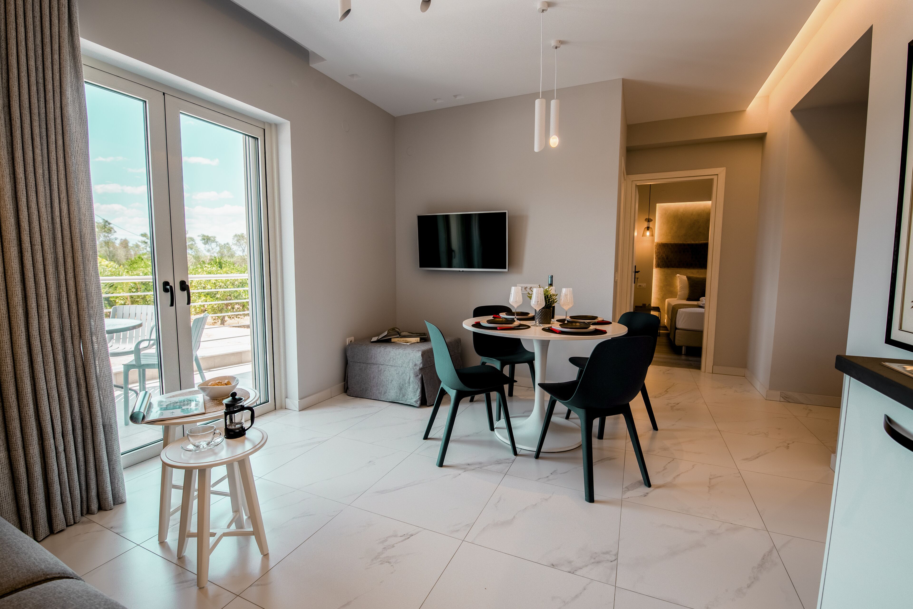 A modern dining area with a round table, chairs, and a television mounted on the wall.