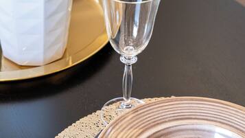 A table with a clear glass, a ceramic plate, and a potted plant.