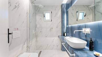 Une salle de bain moderne avec des toilettes blanches, un grand lavabo blanc et un espace douche.