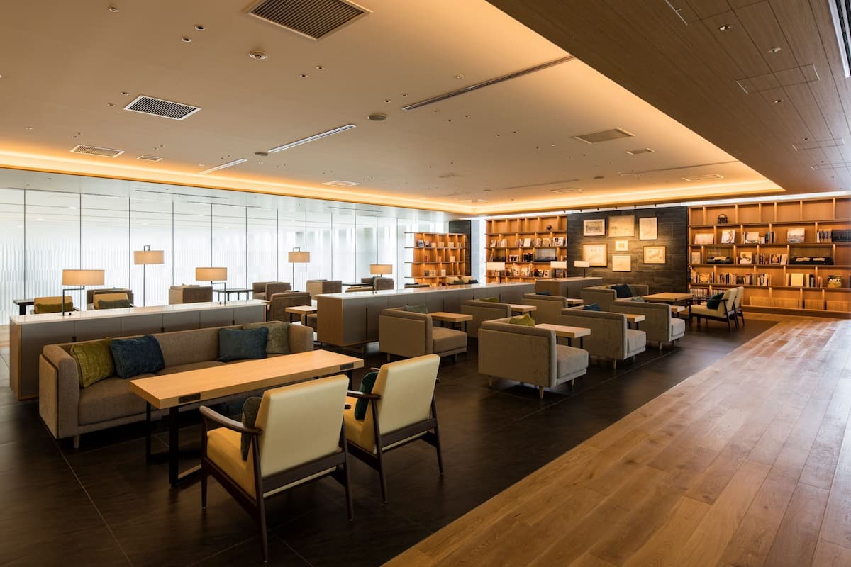 Eine moderne Hotelhalle mit einer langen Rezeption, Sitzbereichen und einer Wand mit gerahmten Bildern.