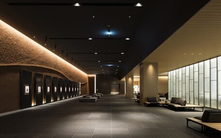 A modern interior with a long corridor, seating areas, and a wall with framed pictures.