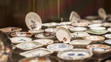 A display of various ceramic dishes with lids, arranged on a glass surface.