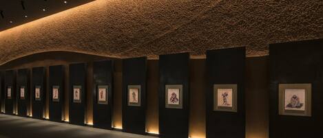 A modern interior with a textured ceiling, recessed lighting, and framed artwork on the walls.