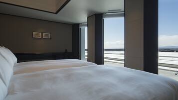 A hotel room with two beds, a large window, and a view of a snowy landscape.