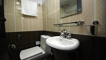Un baño moderno con inodoro, lavamanos y ducha.