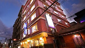 A multi-story hotel with a prominent 'HOTEL BRIGHT STAR' sign, multiple balconies, and a ground-level restaurant with outdoor seating. - Hotel Livin Kathmandu (Kathmandu)