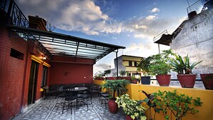 A rooftop patio with outdoor seating, potted plants, and a clear sky. - Hotel Livin Kathmandu (Kathmandu)