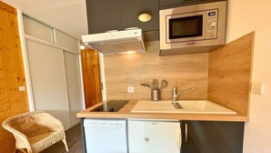 A compact kitchenette with a built-in microwave, a sink, and a dishwasher. - Studio for 4 in Ménuires, renovated, mountain view (Les Menuires)