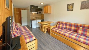 A compact living space with a kitchenette, a sofa, a TV, and a dining table. - Studio for 4 in Ménuires, renovated, mountain view (Les Menuires)