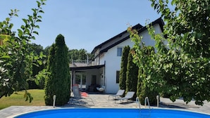 A swimming pool with lounge chairs and a covered patio area. - Green Wood Residence (Ghiroda)