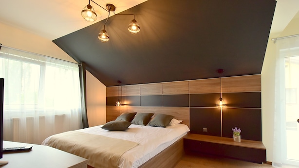 A modern bedroom with a bed, bedside table, and a built-in bench. - Green Wood Residence (Ghiroda)