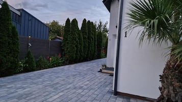 A paved driveway leading to a building with a white exterior wall and a number '1' sign.