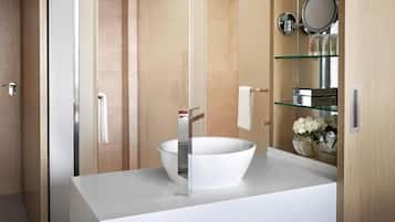 A modern bathroom with a white sink, glass shelves, and a mirror.