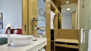 Un baño moderno con un lavamanos grande de color blanco, un espejo y un mueble de tocador de madera.