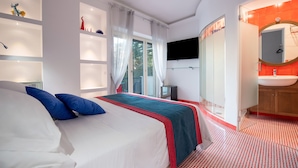 A modern hotel room with a large bed, a TV, a bathroom with a red and white patterned floor, and a large window with curtains. - Aquae Romanae Piazza Lauro (Sorrento)