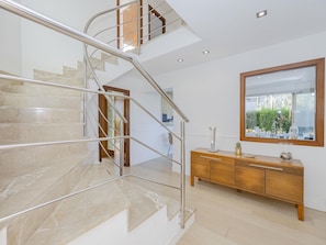A modern interior with a marble staircase, a wooden console, and a large mirror reflecting a view. - Villa Salines House · Villa with private pool in Puerto de Alcúdia (Puerto de Alcudia)