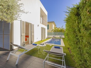 A modern outdoor pool area with lounge chairs and a small table with glasses. - Villa Salines House · Villa with private pool in Puerto de Alcúdia (Puerto de Alcudia)