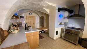 A kitchen with an arched ceiling, a built-in oven, and a coffee maker on the counter.
