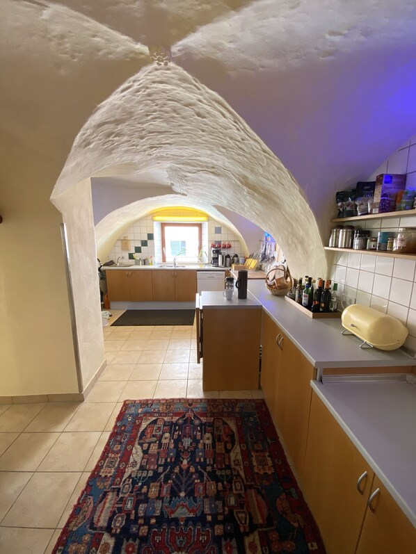 Une cuisine dotée d’un plafond en arc de cercle, d’un îlot central et d’un tapis à motifs.