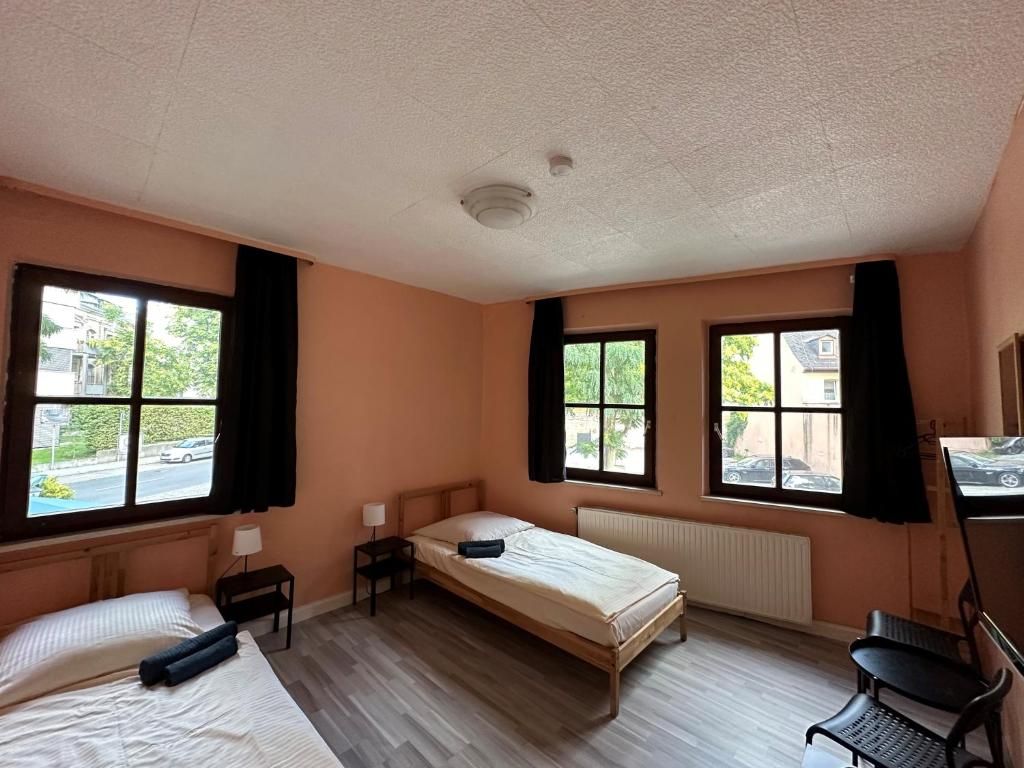 Ein Zimmer mit zwei Betten, einem Schreibtisch und einem Stuhl.