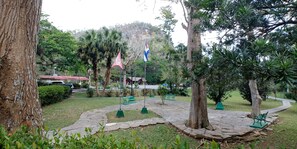 Un parc avec des allées pavées, des bancs et des drapeaux.