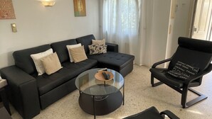 A modern living room with a sectional sofa, a glass coffee table, and a black lounge chair. - Oliva: House / Villa - Oliva (Oliva)