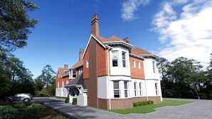 Une maison à deux étages avec une façade en briques, des éléments décoratifs blancs et une grande pelouse devant.