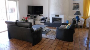 Un soggiorno con una TV a schermo piatto, un camino, un divano e un tavolino da caffè.