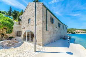 A stone building with a balcony overlooking a body of water. - Luxury Villa Gabriela (Korcula)