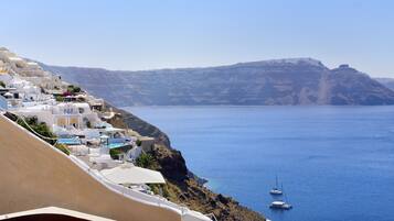 A coastal village with white buildings, a clear blue sea, and boats.