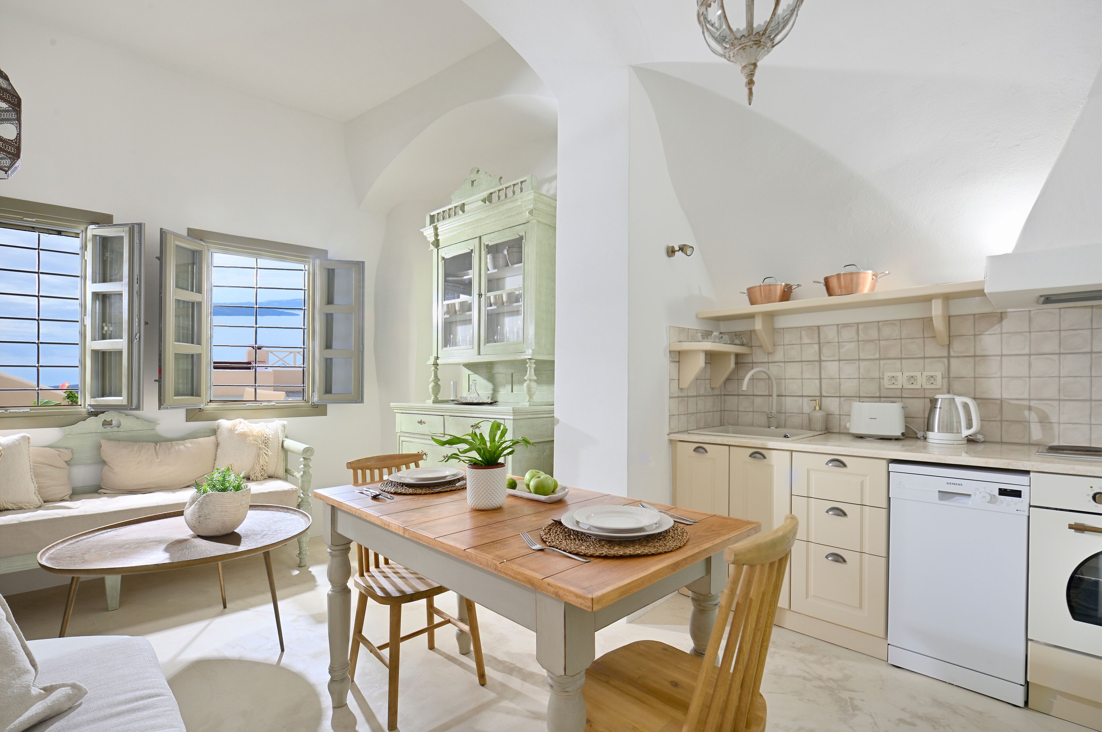 A kitchen with a dining table, chairs, a built-in cabinet, and a dishwasher.
