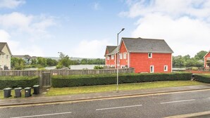 A red house with a grey roof, a street lamp, and a wooden fence. - Mallard Cottage (Aylesford)